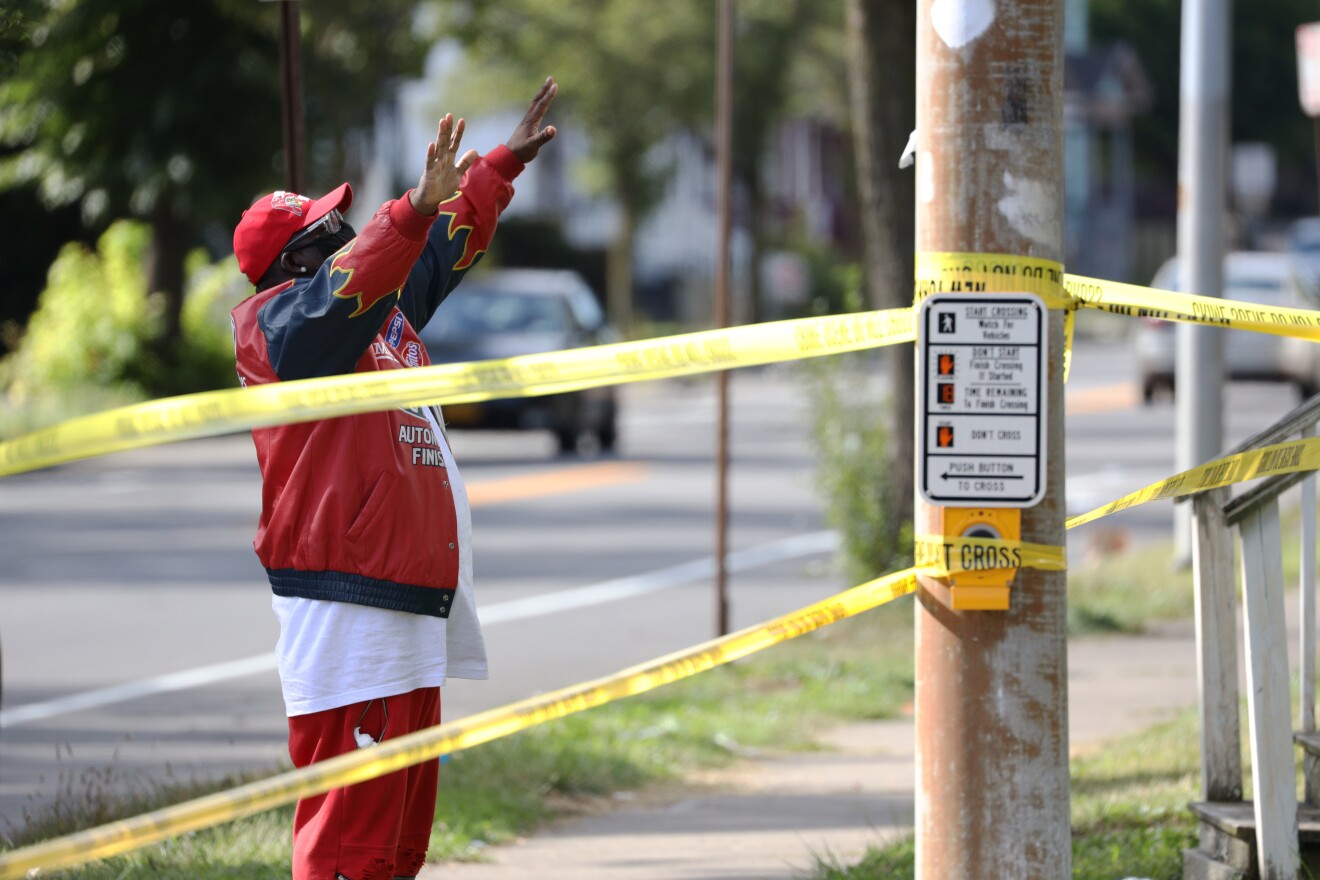 Bishop Patrick McNair prays on the corner of Pennsylvania Avenue and North Goodman Street after a mass shooting erupted during a house party early Saturday on Pennsylvania Avenue.